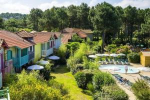an aerial view of a resort with a pool and umbrellas at Maison sur golf avec piscine chauffée à Lacanau Océan in Lacanau