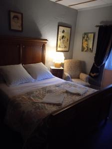 1 dormitorio con 1 cama grande y 1 silla en APPARTEMENT INDEPENDANT DANS MAISON PARTICULIERE en Bayet