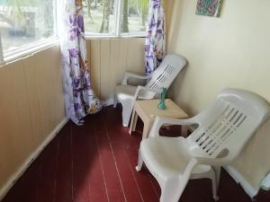 - deux chaises blanches en plastique et une table dans une pièce dans l'établissement Buccaneer Resort, à Bocas del Toro