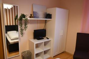 a small room with a television and a small bed at Hotel-Pension Charlottenburg in Berlin