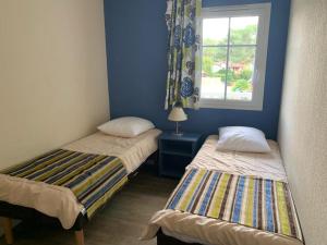 two beds in a room with a window at Maison sur golf avec piscine chauffée à Lacanau Océan in Lacanau +27 photos