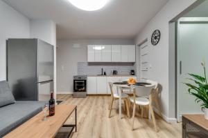 a kitchen and a living room with a table and chairs at Central Platinum Apartments 16 in Rybnik +15 photos