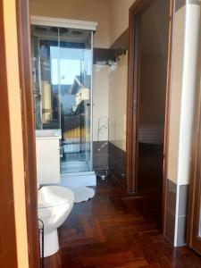 een badkamer met een toilet en een glazen douche bij B&B La Tartaruga in Pregnana Milanese