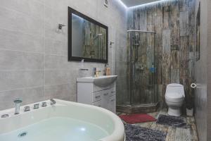 a bathroom with a tub and a sink and a toilet at Апартаменты в гостевом домике in Almaty