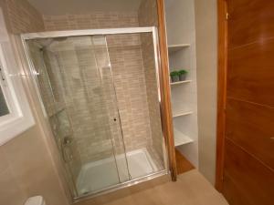 y baño con ducha y puerta de cristal. en Vilamarlux VI, en Vilassar de Mar