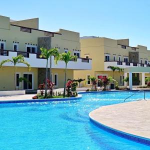 a large swimming pool in front of a building at Las Palmas Beach Hotel in Dixon Cove