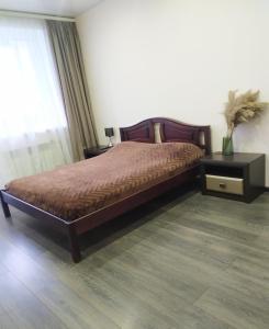 ein Schlafzimmer mit einem Bett, zwei Tischen und einem Fenster in der Unterkunft Apartment on Klochkovskaya 152a in Kharkov