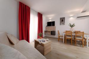 een woonkamer met een bank en een eetkamer bij Apartments Grota in Poreč