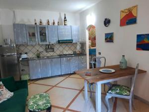 een keuken met een houten tafel en een koelkast bij La casa nella roccia in Napels