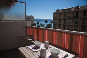 a table on a balcony with a view of a city at Stylish Studio in only 50 meters from beach ! in Nice