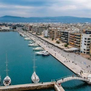 eine Brücke über einen Hafen mit Booten im Wasser in der Unterkunft GKSuite Volos in Volos