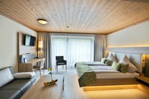 een hotelkamer met een bed en een bank bij Deeke's Quellenhof in Lübbecke