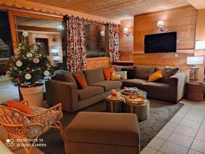 een woonkamer met een bank en een kerstboom bij Chalet Altitude 1057 in Chamonix-Mont-Blanc