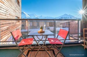 een patio met een tafel en stoelen op een balkon bij Appartement Queyrelet Orcières in Orcières