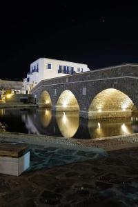 a stone bridge over a body of water at night at Sunloft-Paros in Naousa