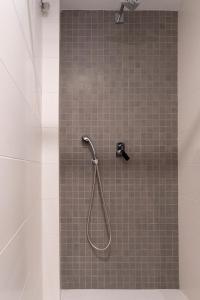 a shower with a hose in a bathroom at Moontels Paseo de Ruzafa in Valencia