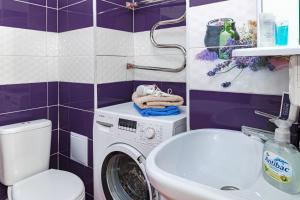 a bathroom with a washing machine and a sink at Apartments 7 Я-21/5-39 in Astana +10 photos