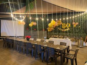 una mesa larga y sillas en una habitación con globos en Hotel La Chelita, en Nilo