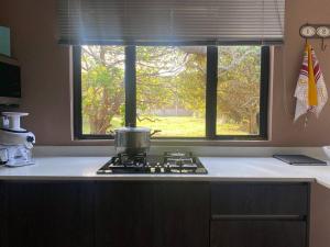 a kitchen counter with a stove and a window at 7th Heaven in Tugela Mouth