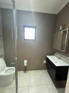 a bathroom with a toilet and a sink and a shower at 7th Heaven in Tugela Mouth