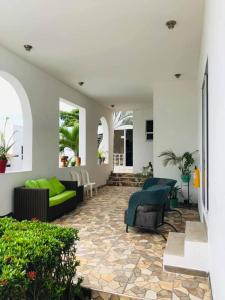 - un salon avec un canapé et des chaises sur une terrasse dans l'établissement Hotel La Chelita, à Nilo