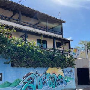 un immeuble avec graffiti sur son côté dans l'établissement Enseada Hostel, à Arraial do Cabo