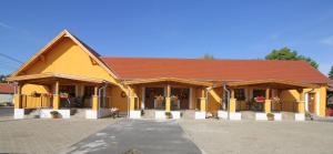 a large yellow building with a red roof at Radics Panzió Étterem és Pihenő Központ in Letenye