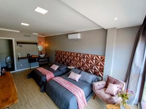 1 dormitorio con 2 camas y sofá en Pousada Doce Lar, en Penha