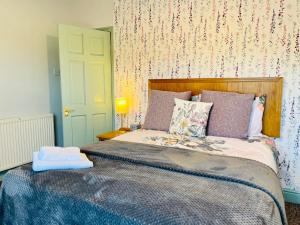a bedroom with a bed with a blue comforter at Purple Cloud Cottage in Portsmouth