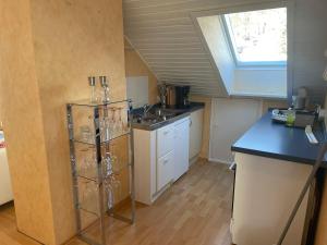 uma pequena cozinha com um lavatório e uma janela em Haus Harzlich em Braunlage