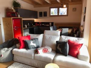 a living room with a white couch with red and black pillows at Cèsa Prinoth in Campitello di Fassa