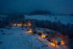 a group of lodges in the snow at night at Osada Pstrąga in Stronie Śląskie