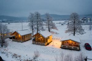 a group of cottages in a snow covered field at Osada Pstrąga in Stronie Śląskie