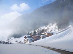 伊施格爾的住宿－Sun Lodge，一座雪覆盖的山中,有房子和滑雪场