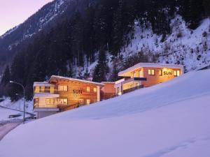 a group of buildings in front of a snow covered mountain at Sun Lodge in Ischgl