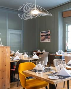 un comedor con mesas y sillas y una lámpara de araña en Hotel Rosatsch, en Pontresina