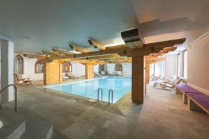 a large swimming pool in a building with wooden beams at Hotel Rosatsch in Pontresina