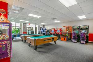 a gaming room with pool tables and arcade machines at Silver Lake Resort in Orlando