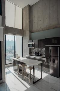 cocina con mesa y sillas y algunas ventanas en Luxury Loft Monterrey City Living at Landmark High Rise, en Monterrey