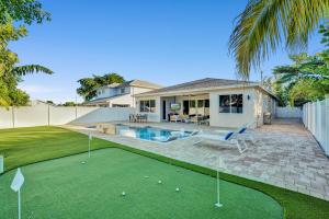 a house with a pool and a putting green at Mimosa Sunrise Villa in Pompano Beach
