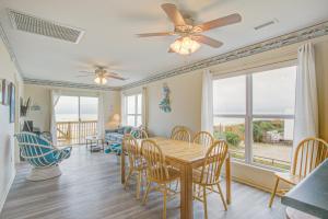 a dining room with a table and chairs and a ceiling fan at 1 Anchors Away Oceanfront in Holden Beach