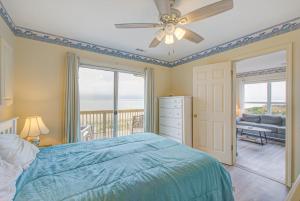 a bedroom with a bed and a ceiling fan at 1 Anchors Away Oceanfront in Holden Beach