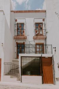a white building with two balconies and a door at Matiana Estudiante in Zacatecas