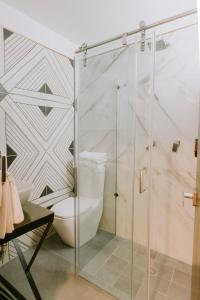 a bathroom with a toilet and a glass shower at Matiana Estudiante in Zacatecas +26 photos