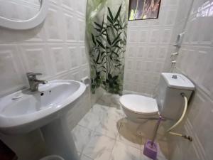 a white bathroom with a sink and a toilet at Menai Bay Beach Bungalows in Unguja Ukuu +121 photos