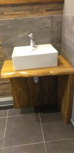 lavabo blanco en una encimera de madera en el baño en Au grand galop, en Eu 29 fotos más