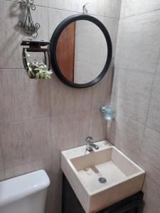 La salle de bains est pourvue d'un lavabo et d'un miroir. dans l'établissement PIEDRALAGO CABAÑAS Y TURISMO, à Villa Carlos Paz