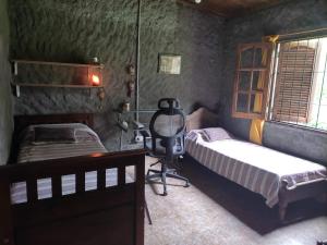 a bedroom with two beds and a desk and a mirror at Casa de Campo en Raco in Raco