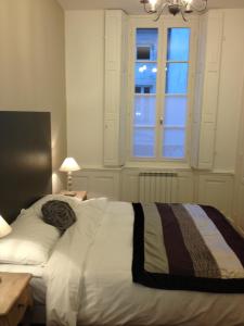 een slaapkamer met een wit bed en een raam bij Pat & Co in Beaune