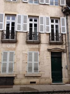 un edificio con finestre bianche e una porta verde di Pat & Co a Beaune